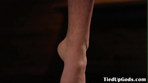 Suspended bdsm sub caged for cock tugging